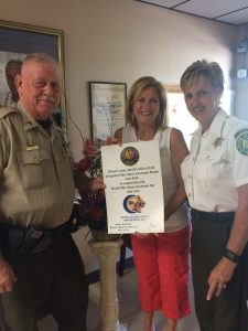 WCSO Sgt. Don Witherspoon (left) and SCAN Director (right) Debbie Pare help bring awareness to World Elder Abuse Awareness Day with Teresa Botts at the Lebanon Senior Center.