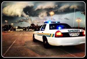 Photo of Sheriff patrol vehicle in parking lot with storm clouds in the distance